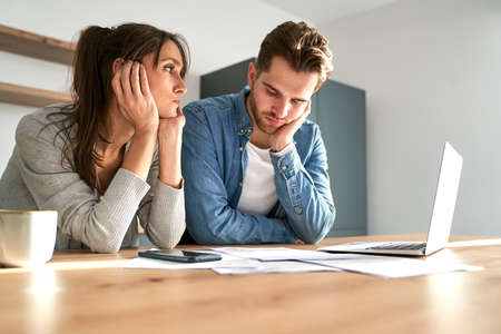 Miserable young caucasian couple having financial problems due to new house