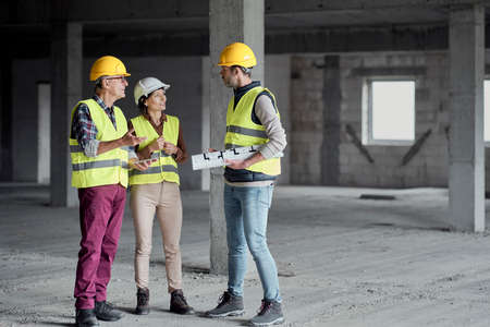 Three caucasian engineers discussing together on the construction siteの写真素材
