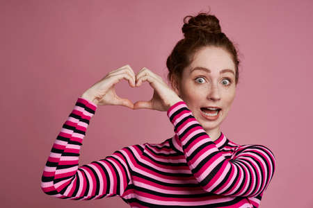 Studio shot of young woman showing heart shape with handsの写真素材