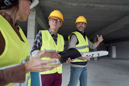 Three caucasian engineers discussing on the construction siteの写真素材
