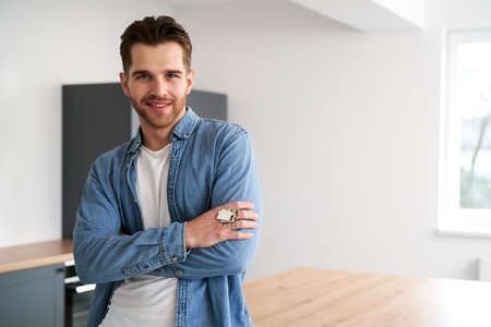 Portrait of young caucasian man holding a bunch of keys of new flatの写真素材