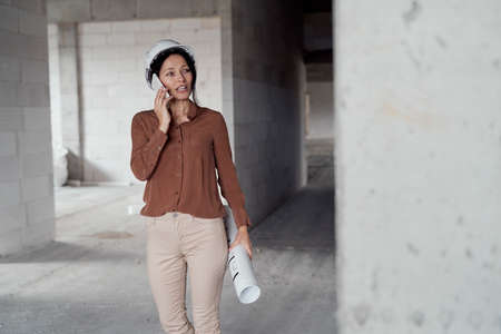 Female mature caucasian engineer walking on construction site