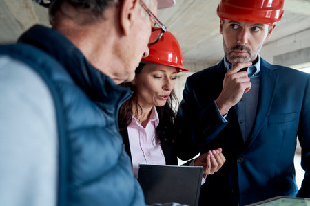 Group of caucasian engineers and investors discussing on construction siteの写真素材