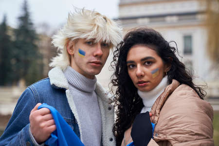 Portrait of caucasian couple with Ukrainian flags on cheeksの写真素材