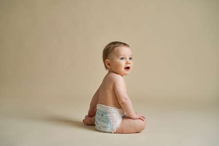Little caucasian baby sitting on nude backgroundの写真素材