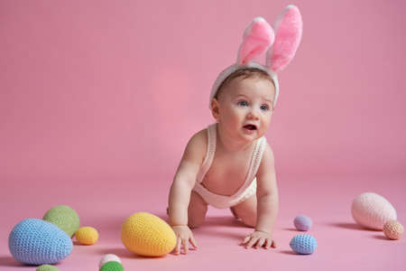 Crawling little baby wearing bunny costume at studio shot
