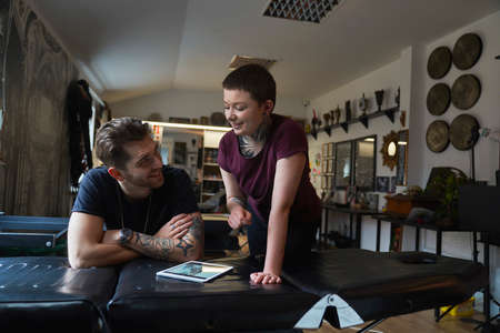 Two caucasian people with tattoo discussion about new projectの写真素材