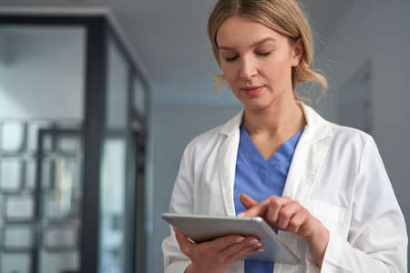Caucasian female doctor using digital tablet in medical clinic