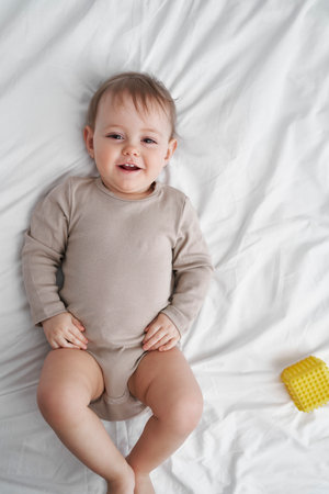 Portrait of smiling little baby lying in bed