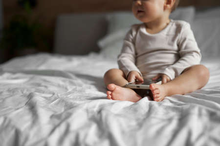Caucasian little girl holing mobile phone in handsの写真素材