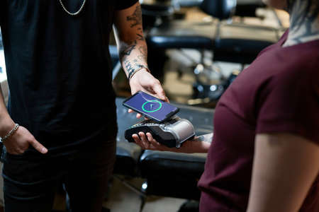 Close up of caucasian woman taking a pay in tattoo studio