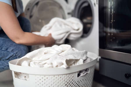 Close up of caucasian woman making laundry at homeの写真素材