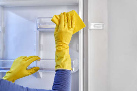 Close up of caucasian woman cleaning fridge at homeの写真素材