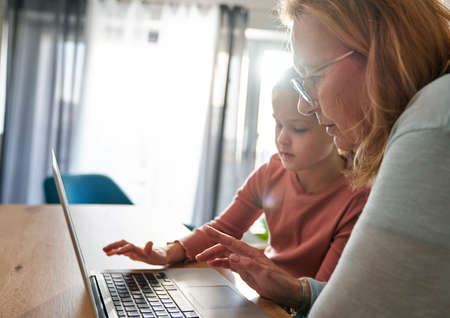 Caucasian of grandmother and her granddaughter using laptop together at homeの写真素材
