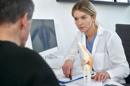 Young caucasian female doctor talking with patientの写真素材