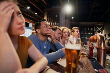 Cheering friends of soccer fans in the pub
