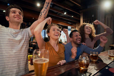 Cheering friends of soccer fans in the pubの写真素材