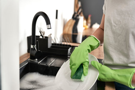 Close up of caucasian woman washing the dishesの写真素材