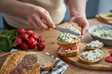 Woman making preparing sandwich of cottage cheeseの写真素材