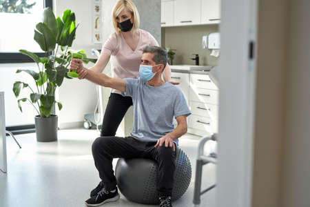 Female physical therapist working with senior man