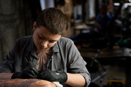 Close up of tattoo artist drawing on arm of clientの写真素材