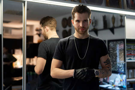Close up of young adult man of tattoo salon