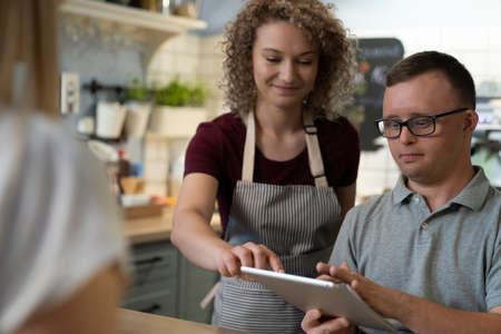 Caucasian man with down syndrome learning how to take orders