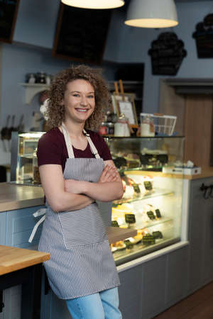 Portrait of young caucasian woman in the bakeryの写真素材
