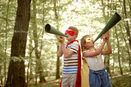 Little boy and girl wearing superhero costume have news about environmentの写真素材