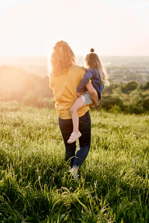 Caucasian woman walking with daughter at the meadowの写真素材