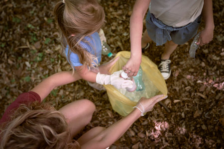 Caucasian family picking up trash to garbage bag from forest