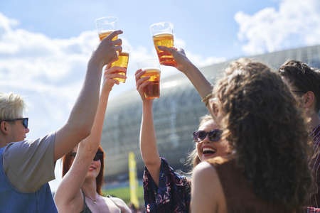 Group of caucasian friends make toasting beer at festival