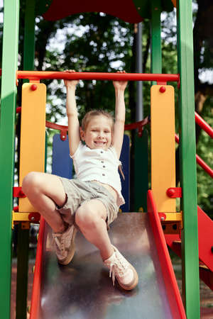 Portrait of caucasian girl playing at sliding in summer dayの写真素材