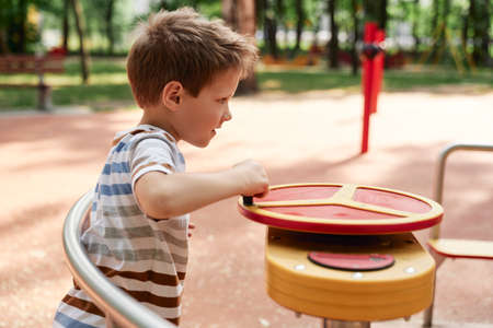 Caucasian little boy playing at playground in summer dayの写真素材