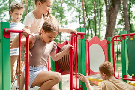 Group of kids playing at the playground in summer day