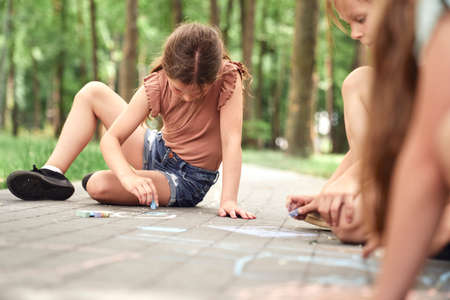 Group of kids coloring with chalk in summer dayの写真素材