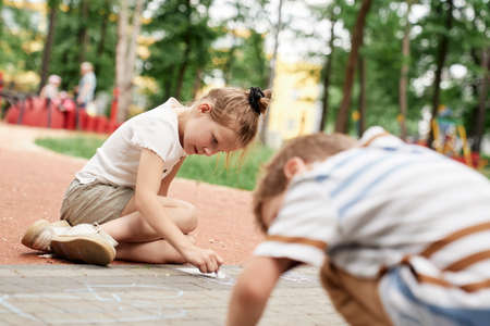 Group of kids coloring with chalk in summer dayの写真素材