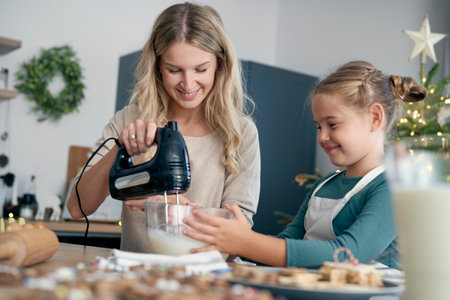 Caucasian mother and daughter preparing sweet food in the kitchen before Christmas