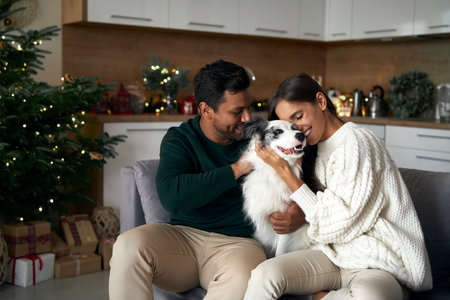 Multi ethnicity couple bonding with dog at Christmas timeの写真素材