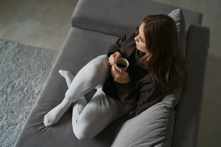 From above of woman drinking cafe at homeの写真素材