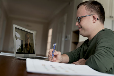 Caucasian man with down syndrome having lesson online