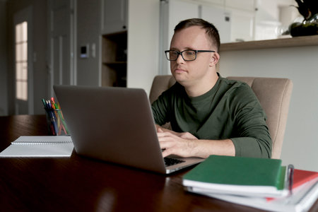 Man with down syndrome using laptop while studying at home