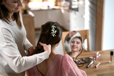 Caucasian mother help her daughter with preparing to promの写真素材