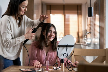 Caucasian mother help her daughter with preparing to promの写真素材