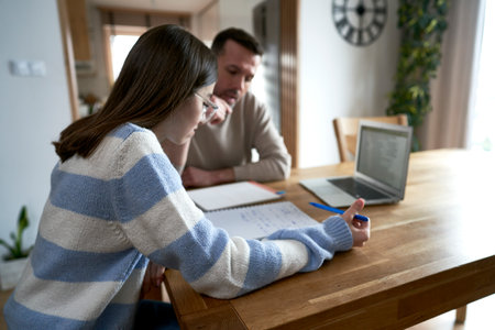 Caucasian father with teenager daughter make homework at home