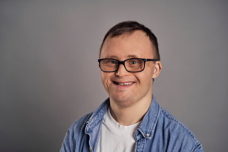 Portrait of man with down syndrome on gray backgroundの写真素材