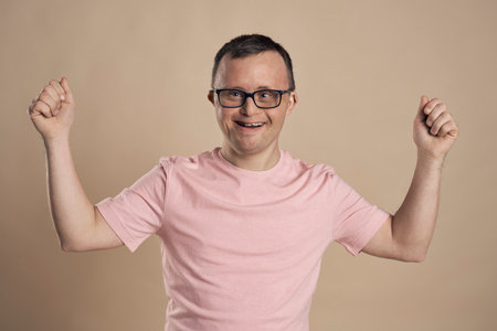 Man with down syndrome celebrating success at nude backgroundの写真素材