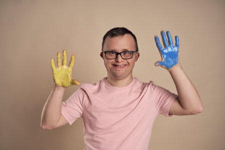 Man with down syndrome with painting hands on colorfulの写真素材