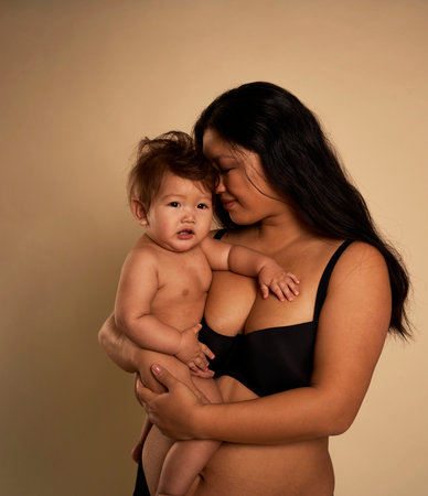 Asian woman in underwear embracing a toddlerの写真素材