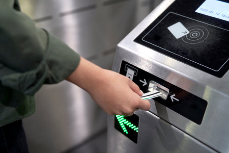 Unrecognizable woman putting ticket to the turnstile in the underground